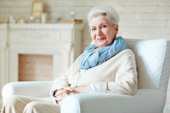 Happy Mature Woman Sitting on a Couch