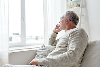 Senior man looking out window