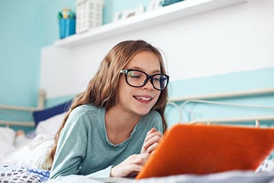 Young student on laptop in her bed